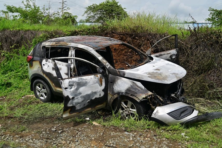 Los restos de un vehículo incinerado presuntamente utilizado por los asesinos de un coronel de las Fuerzas Armadas del Ecuador aparecen al costado de una carretera en Guayaquil, Ecuador, el 14 de febrero de 2025.