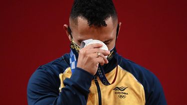 Luis Mosquera, medallista de plata de Colombia, reacciona mientras se para en el podio de la ceremonia de la victoria de la competencia de halterofilia masculina de 67 kg durante los Juegos Olímpicos de Tokio 2020&nbsp;