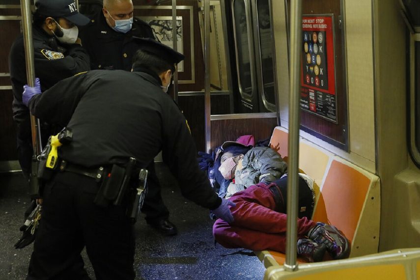 Polic&iacute;as despiertan a una persona para poder sacarla del tren subterr&aacute;neo en la ciudad de Nueva York el 30 de abril del 2020.&nbsp;
