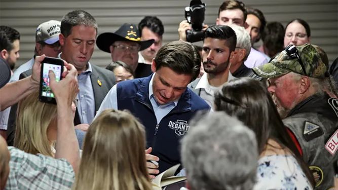 Ron DeSantis, gobernador de Florida y candidato a la nominación republicana por la Casa Blanca, firma autógrafos a seguidores en Iowa.