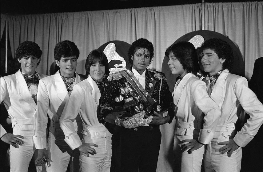 En esta foto del 28 de febrero de 1984, Michael Jackson, en el centro, posa entre bambalinas con el grupo Menudo durante la ceremonia de los premios Grammy en Los Ángeles. De izquierda a derecha Charlie Massó, Robby Rosa, Roy Roselló, Jackson, Ray Reyes y Ricky Meléndez. Reyes, miembro de Menudo durante la era dorada del quinteto puertorriqueño, murió el viernes 30 de abril de 2021. Tenía 51 años.&nbsp;