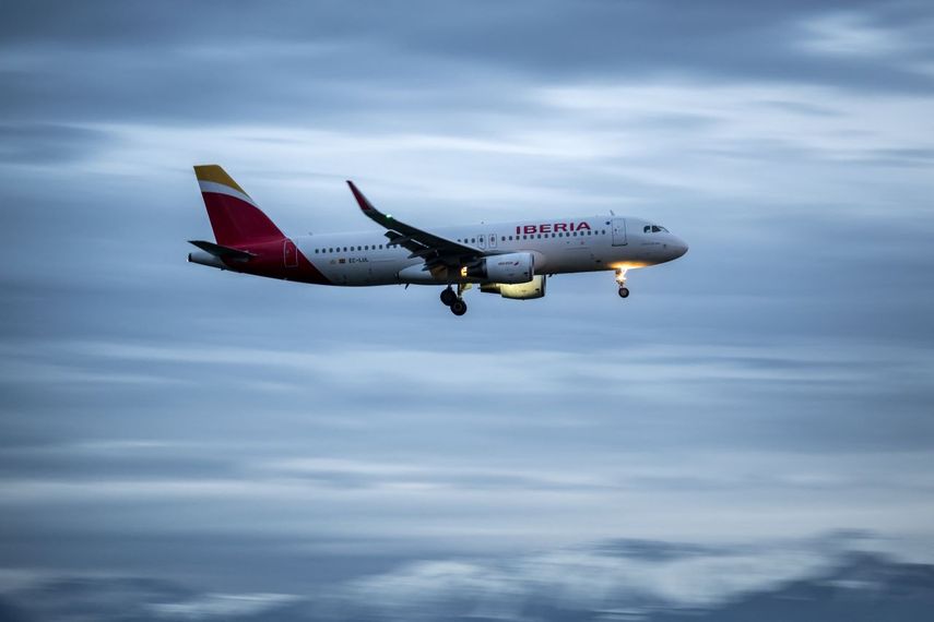 Un avión comercial Airbus A320-216 de Iberia aterrizando.