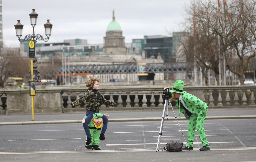 Personas vestidas para el D&iacute;a de San Patricio se toman fotos en el centro de Dubl&iacute;n, el martes 17 de marzo de 2020.&nbsp;