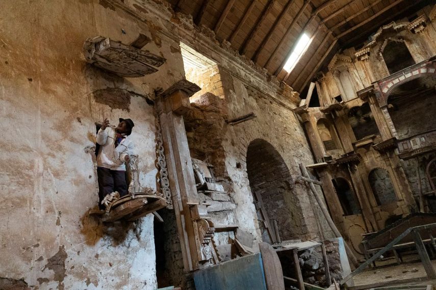 El pastor de alpacas Esteban Taipe, sube al púlpito de la iglesia abandonada del pueblo fantasma de Santa Bárbara, Perú, el jueves 2 de diciembre de 2021. Durante la época colonial española, Santa Bárbara fue la mina de mercurio más grande de América.
