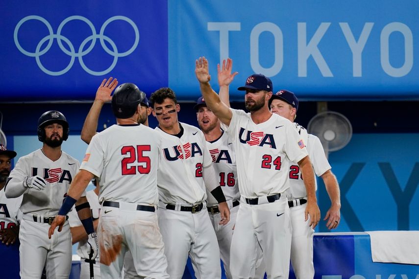 Todd Frazier (25), de Estados Unidos, celebra con sus compañeros tras anotar en un hit de Mark Kolozsvary en el juego de semifinales del torneo olímpico de béisbol