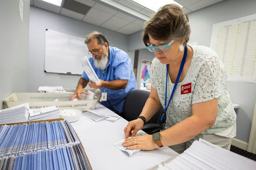 Dawn Stephens y Duane Taylor preparan boletas para votar que serán enviadas por correo postal, en la Junta Electoral del condado Mecklenburg, en Charlotte, Carolina del Norte.