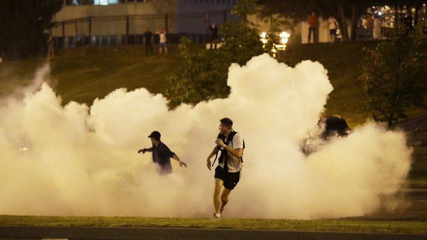 Manifestantes corren en medio del humo durante una protesta el domingo 9 de agosto de 2020 tras las elecciones presidenciales, en Minsk, Bielorrusia.&nbsp;