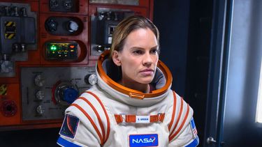Esta imagen difundida por Netflix muestra, de izquierda a derecha, a Mark Ivanir, Hilary Swank y Ray Panthaki de la nueva serie Away, que se estrenará el 4 de septiembre