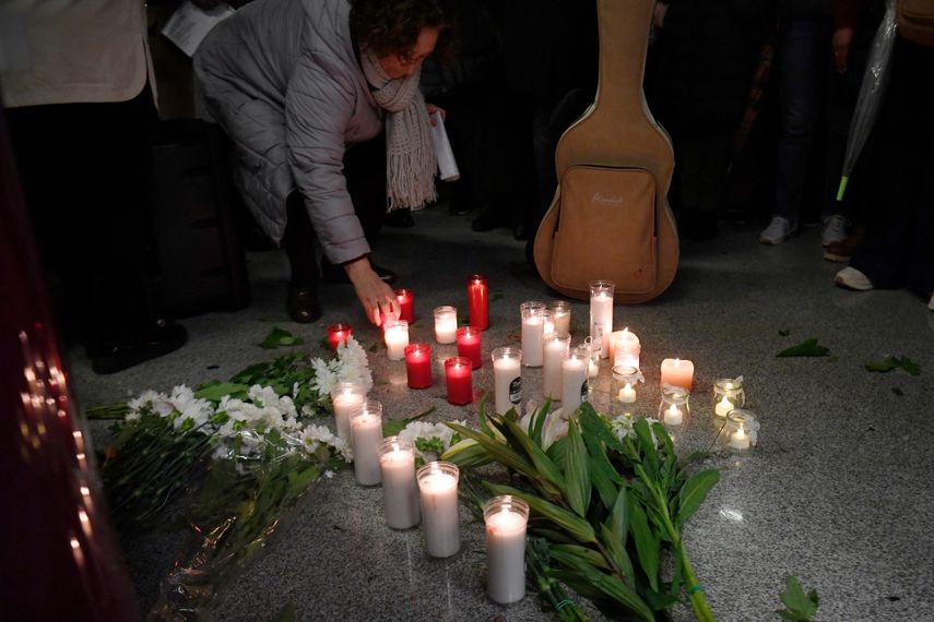 Una mujer pone una vela mientras la gente se reúne para una vigilia en honor a las víctimas del accidente de tren de alta velocidad del 18 de enero, que causó la muerte de 45 personas en Adamuz, el 25 de enero de 2026, en la estación de tren de Huelva (España)