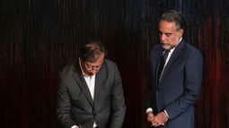 En esta foto proporcionada por la presidencia de Colombia el 24 de agosto de 2022, el presidente Gustavo Petro (izq.) firma un decreto que designa a Mario Benedetti como nuevo embajador en Venezuela, en el palacio presidencial de Nariño en Bogotá.