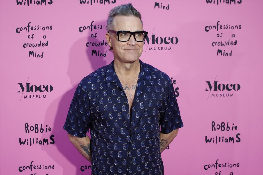 El cantante Robbie Williams posa en el photocall de la exposición Confessions, en el Moco Museum, a 20 de junio de 2024, en Madrid (España).