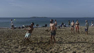 La gente juega en una playa cerca de Atenas, Grecia, el 10 de enero de 2021, ya que las temperaturas superan los 20 grados centígrados. &nbsp;