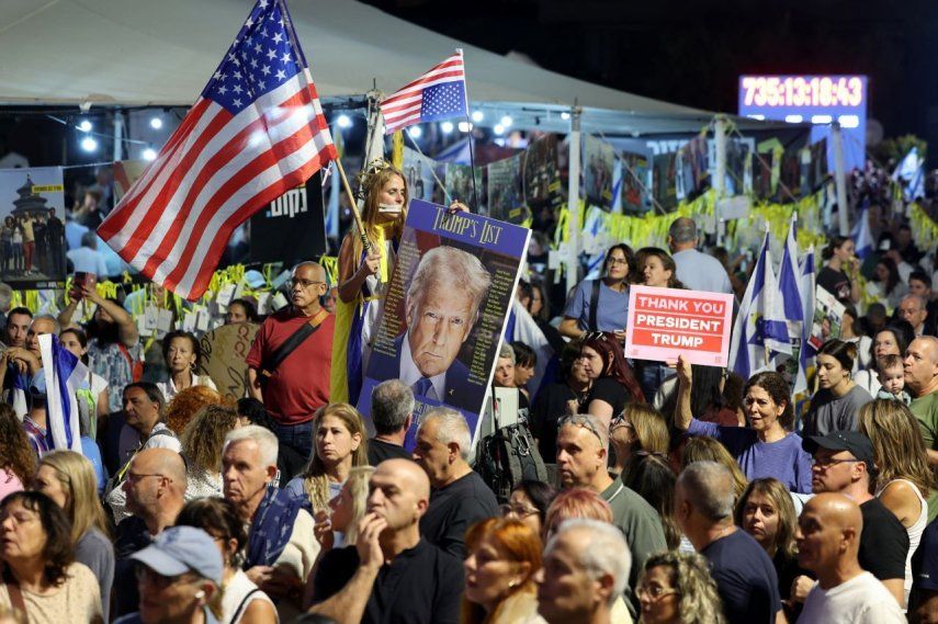 Miles de israelíes ondean banderas de Estados Unidos y un retrato del presidente Donald Trump durante una reunión frente al Museo de Arte de Tel Aviv, conocido como la Plaza de los Rehenes en Tel Aviv, el 11 de octubre de 2025.