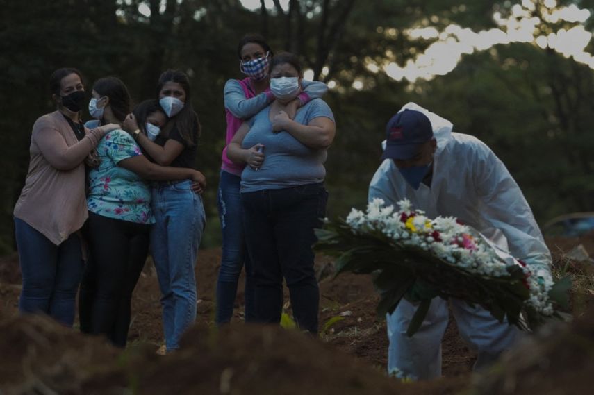 Familiares de una víctima de la enfermedad del nuevo coronavirus COVID-19 lloran mientras su ser querido es enterrado en el cementerio de Vila Formosa en Sao Paulo, Brasil, el 31 de marzo de 2021.&nbsp;