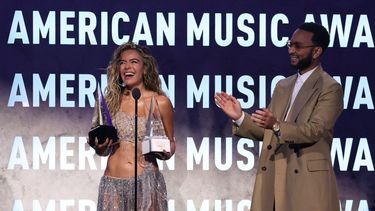 La cantante colombiana Karol G reacciona mientras el cantautor estadounidense John Legend le entrega el Premio Internacional a la Excelencia Artística y el premio al Mejor Álbum Latino por Tropicoqueta durante los American Music Awards en el MGM Grand Garden Arena de Las Vegas, Nevada, el 25 de mayo de 2026.&nbsp;