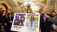 La senadora Joni Ernst, republicana por Iowa, sostiene un cartel con fotografías de dos víctimas de asesinato Sarah Root y Laken Riley en el Capitolio, en Washington, el martes 27 de febrero de 2024.   