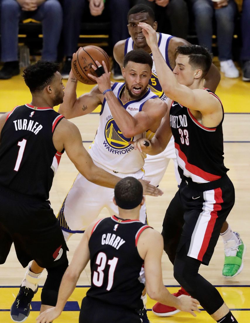 Stephen&nbsp;Curry&nbsp;(c) de los Golden State Warriors en acción contra Evan Turner (i), Seth&nbsp;Curry&nbsp;(abajo) y Zach Collins (d) de Portland Trail Blazers durante el primer juego de las finales de la Conferencia Oeste de la NBA, en el Oracle Arena de la ciudad de Oakland, California.