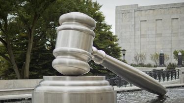 Escultura de un martillo de juez en una piscina.