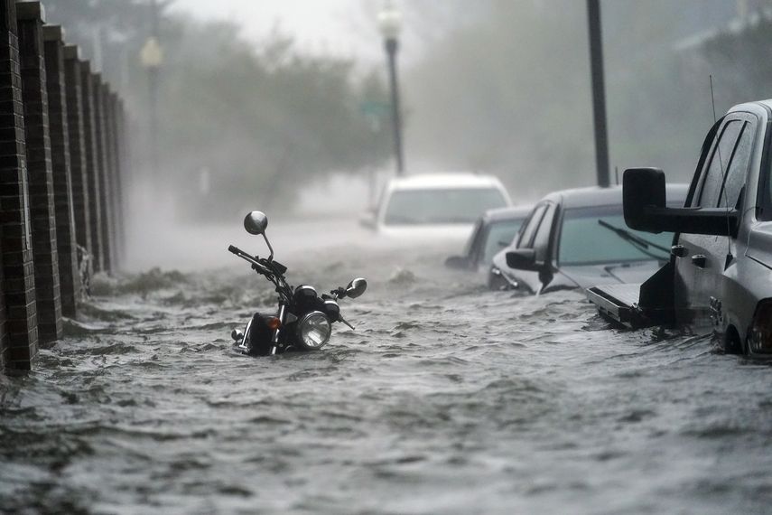 Autos y una motocicleta en una calle inundada el mi&eacute;rcoles 16 de septiembre de 2020 en Pensacola, Florida. El hurac&aacute;n Sally Toc&oacute; tierra el mi&eacute;rcoles cerca de Gulf Shores, Alabama, como tormenta de categor&iacute;a 2.