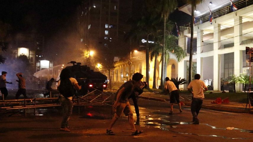 Manifestantes se enfrentan a la policía este viernes 31 de marzo de 2017, en las afueras de la sede del Congreso Nacional en Asunción, Paraguay.