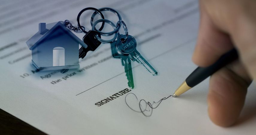 Una persona firma una compraventa de vivienda.