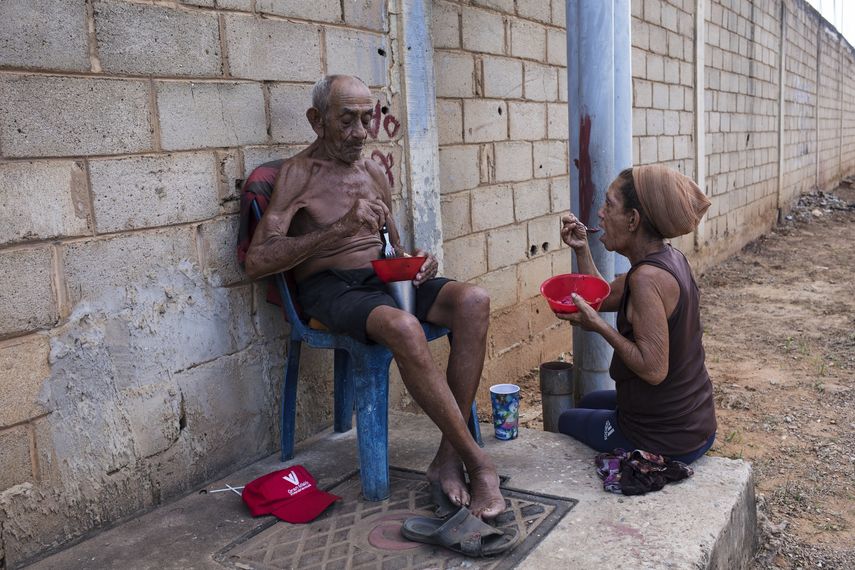 Hayd&eacute; Chac&iacute;n (der) y su esposo Jos&eacute; Calder&oacute;n comen algo donado por vecinos del barrio Los Hijos de Dios en Maracaibo, Venezuela, el 19 de noviembre del 2019. La anciana pareja sobrevive gracias a la caridad ajena.