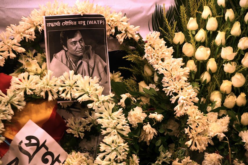 Una foto del fallecido actor indio Soumitra Chatterjee se ve en guirnaldas colocadas junto a su cuerpo durante su funeral en Calcuta el 15 de noviembre de 2020.&nbsp;