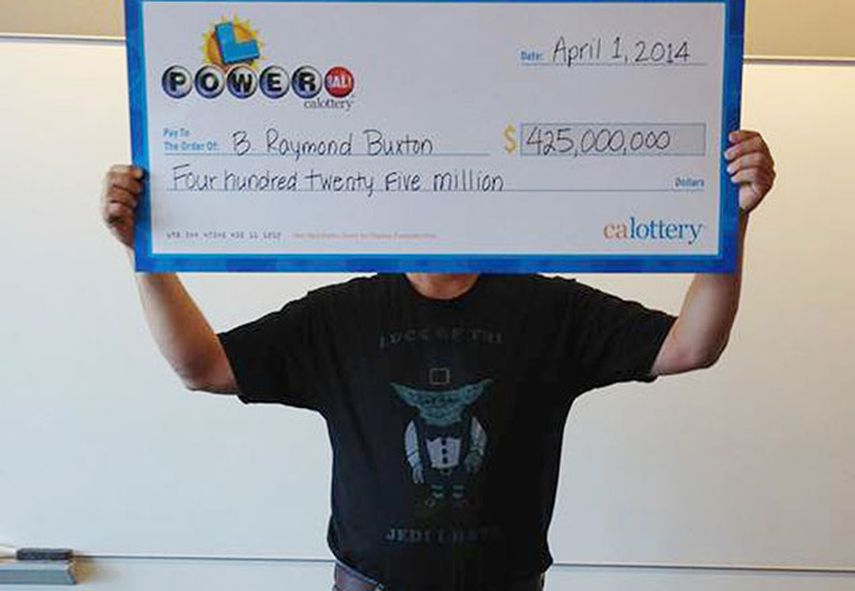 B. Raymond Buxton, del norte de California, se cubre la cara mientras muestra su cheque gigante con el premio de 425 millones de dólares que ganó en el sorteo de la lotería Powerball después de que acudiera a reclamarlo en Sacramento, California. (AP F