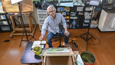Esta fotografía tomada el 25 de mayo de 2022 muestra al instructor de arte japonés Harumichi Shibasaki pintando con acuarelas en su taller en Isumi, prefectura de Chiba. Harumichi Shibasaki tenía casi 70 años cuando comenzó a hacer tutoriales de arte en YouTube desde su tranquilo hogar en el campo japonés.