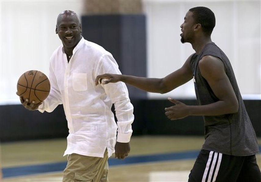 Charlotte Hornets owner Michael Jordan, left, jokes with forward Michael Kidd-Gilchrist, right, during an NBA draft basketball workout in Charlotte, N.C., Tuesd