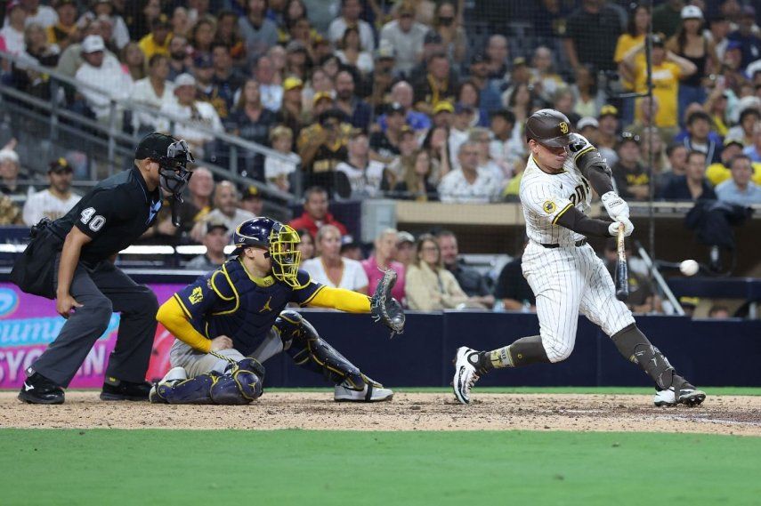 Freddy Fermín #54 de los Padres de San Diego conecta un sencillo productor de oro durante la undécima entrada de un juego, mientras William Contreras #24 de los Cerveceros de Milwaukee observa en el Petco Park el 22 de septiembre de 2025 en San Diego, California. Los Padres de San Diego derrotaron a los Cerveceros de Milwaukee 5-4 para avanzar a los playoffs de la MLB.&nbsp;