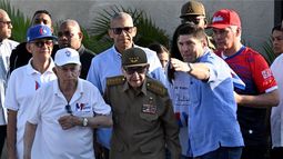 El dictador Raúl Castro (centro vestido de verde olivo) y el exvicepresidente José Ramón Machado Ventura (izquierda) asisten a un mitin del Primero de Mayo en La Habana para conmemorar el Día Internacional de los Trabajadores el 1 de mayo de 2026. El nieto de Raúl Castro, Raúl Guillermo Rodríguez Castro, les indica con la mano derecha hacia dónde deben drigirse.