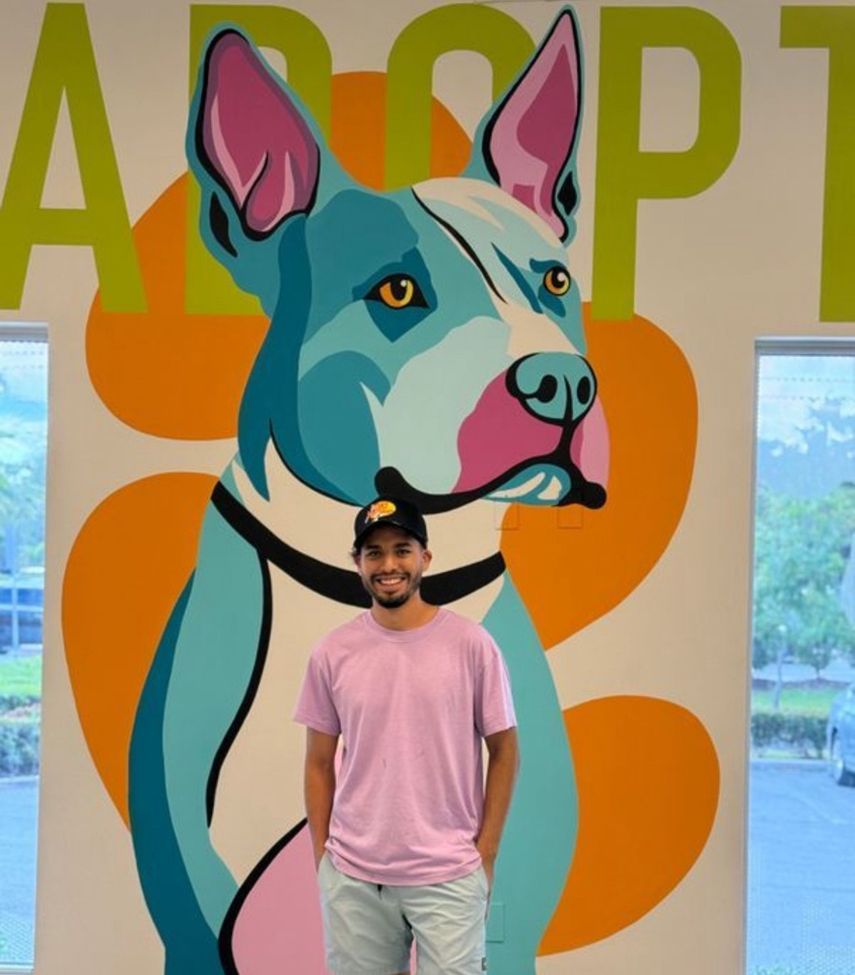 El artista Jonathan Ramírez junto al mural de Russell en los Servicios para Animales de Miami-Dade (MDAS).