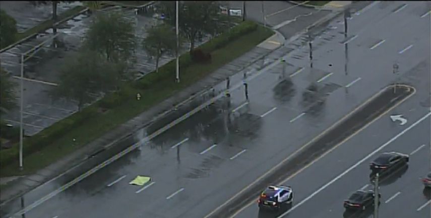 Imágenes aéreas muestran a una persona tirada en la carretera cubierta con una sábana amarilla.