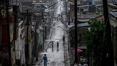 Personas caminan por una calle antes de que el huracán Melissa azote la ciudad de Santiago de Cuba, Cuba, el 28 de octubre de 2025.&nbsp;