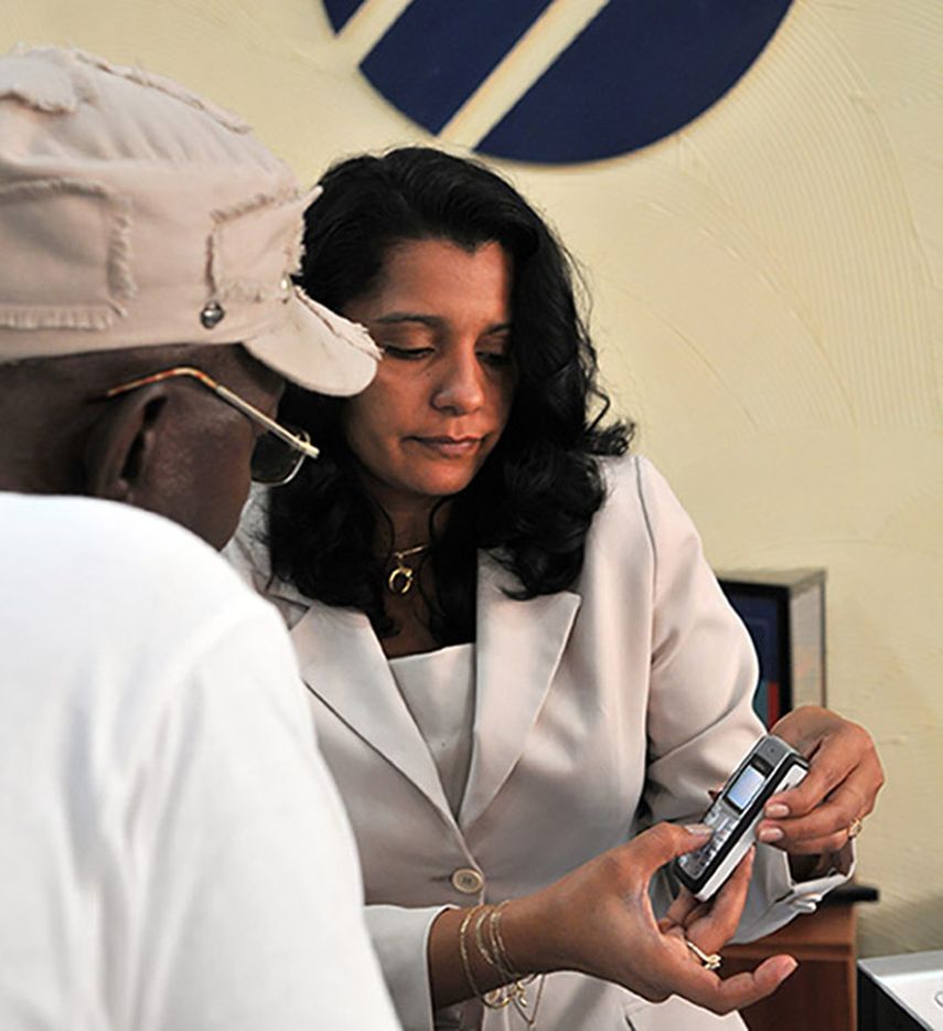 Una empleada de la empresa estatal Cubacel, perteneciente a ETECSA, vende una línea de telefonía celular prepaga a un ciudadano cubano en La Habana. (EFE)