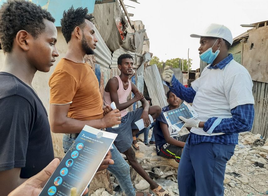 En esta imagen, tomada el 20 de mayo de 2020, migrantes et&iacute;opes varados reciben material informativo sobre c&oacute;mo protegerse del coronavirus, en Bosaso, Somalia.&nbsp;