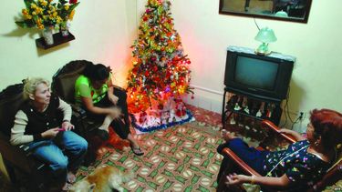 Una familia cubanase reúne en torno a un árbol de Navidad.