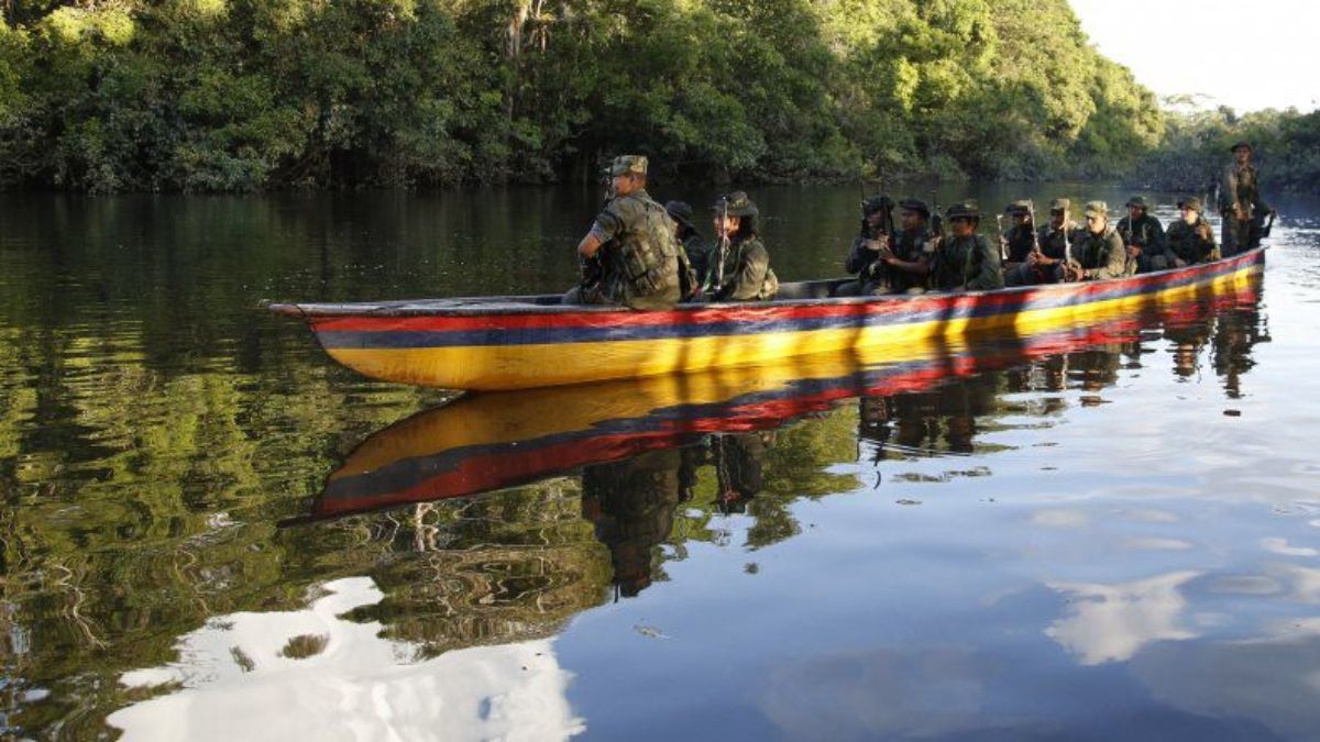 Guerrilleros navegan un río entre Colombia y Venezuela. Guerrilleros navegan un río entre Colombia y Venezuela.