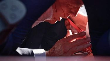 El expresidente Donald Trump en el piso rodeado por agentes del Servicio Secreto y sangre en su rostro después del impacto de bala.