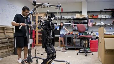 Fotografía del 7 de julio de 2014 que muestra a los investigadores Larry Vadakedathu (izquierda) y Qin He trabajar con un humanoide de 1,50 metros de altura (5 pies) en la Universidad de Pennsylvania en Filadelfia. Un torneo internacional de fútbol ent