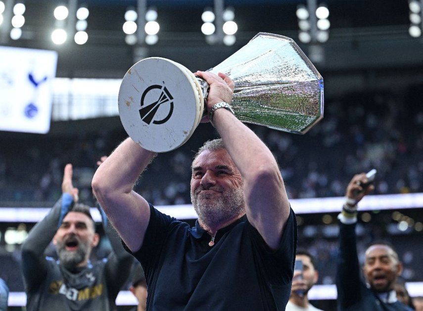 El entrenador greco-australiano del Tottenham Hotspur, Ange Postecoglou, sostiene en alto el trofeo de la Europa League, tras su victoria a mitad de semana en la final de la Europa League el 21 de mayo, mientras él y el equipo lo muestran a los aficionados tras el partido de la Premier League inglesa entre el Tottenham Hotspur y el Brighton and Hove Albion en el Tottenham Hotspur Stadium en Londres, el 25 de mayo de 2025. El Tottenham Hotspur despidió al técnico Ange Postecoglou el 6 de junio, apenas dos semanas después de que el australiano ganara la Europa League para poner fin a la sequía de 17 años de trofeos del club.
