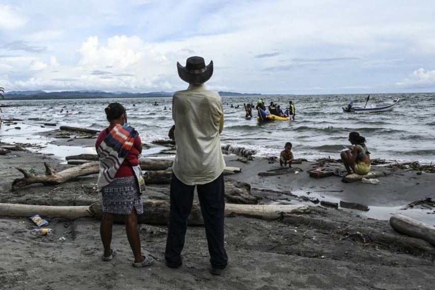 Los residentes ven cómo los migrantes varados de Haití disfrutan de la tarde en la playa mientras esperan un bote que los lleve a Capurgana, cerca de la frontera con Panamá, en Necoclí, Colombia, el 29 de julio de 2021.&nbsp;