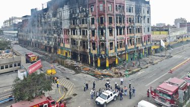 Momento en el que las autoridades policiales trasladan los restos carbonizados de los dos jóvenes que murieron víctimas del incendio en el centro comercial Las Malvinas, en Lima, Perú.