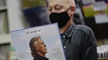 Karl Shale posa con una copia del nuevo álbum McCartney III del músico británico Paul McCartney en la tienda de discos Sounds of Universe en Londres el 18 de diciembre de 2020.&nbsp;
