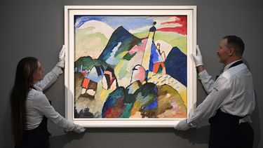 Los empleados posan con una obra de arte titulada Murnau mi Kirche II (Murnau con la Iglesia II) de Wassily Kandinsky, durante una sesión de fotos en la casa de subastas de Sothebys en el centro de Londres el 22 de febrero de 2023.