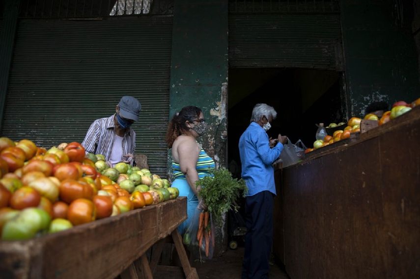 Yuliet Colón, cubana, espera para pagar en un mercado agrícola cerca de su casa en La Habana, Cuba, el viernes 2 de abril de 2021