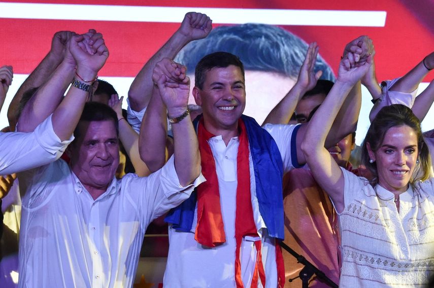 El candidato presidencial paraguayo por el Partido Colorado, Santiago Peña (C), celebra con simpatizantes acompañado por su esposa, Leticia Ocampos de Pea (L), después de ganar las elecciones presidenciales en Asunción, Paraguay.