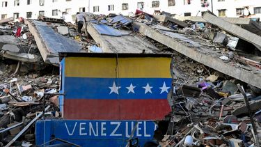 Se observa una bandera venezolana pintada en un muro dañado entre los escombros de un edificio derrumbado tras los terremotos en Caraballeda, estado de La Guaira, Venezuela