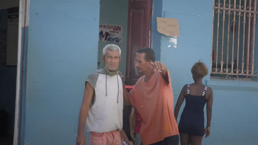 Cubanos frente a un cartel de venta de pan.&nbsp;